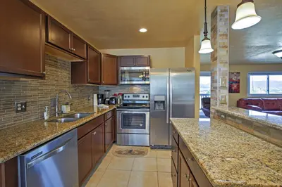 a kitchen with wooden cabinets and stainless steel appliances at 7 Mi to Slopes! Mtn-View Silverthorne Resort Hub in Silverthorne