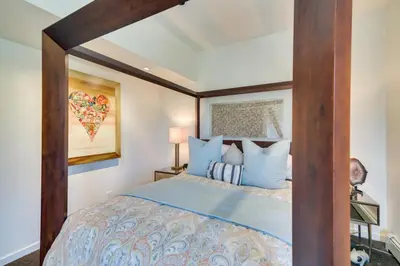 a bedroom with a canopy bed with blue pillows at Boulder Barrett House on Mtn Peak with Hot Tub in Boulder