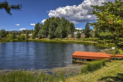a river with a wooden dock in the water at 4 Mi to Granby Ranch Home with Mtn Views in Granby