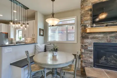 a kitchen and dining room with a table and a fireplace at 4 Mi to Granby Ranch Home with Mtn Views in Granby