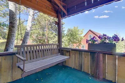 a wooden bench on a porch with a flower box at Hiawatha Peaceful Living in Rocky Mtn Natl Park in Allenspark