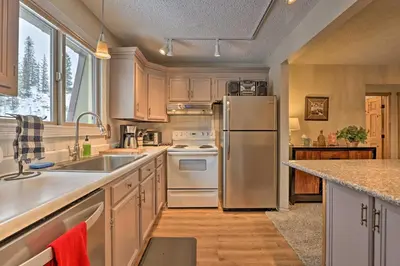 a kitchen with a stainless steel refrigerator and white appliances at Condo on Fraser River Less Than 4 Mi to Winter Park Resort in Winter Park