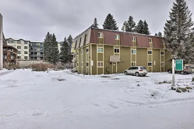 a snow covered parking lot in front of a building at Condo on Fraser River Less Than 4 Mi to Winter Park Resort in Winter Park