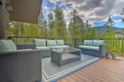 a deck with wicker chairs and a table on a balcony at Luxurious Grand Lake Vacation Rental with Hot Tub! in Grand Lake