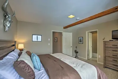 a bedroom with a large bed with blue pillows at Luxurious Grand Lake Vacation Rental with Hot Tub! in Grand Lake
