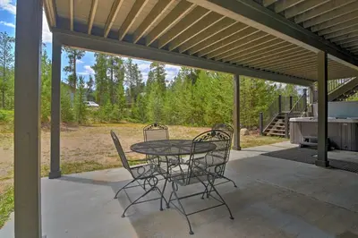a patio with a table and chairs and a grill at Luxurious Grand Lake Vacation Rental with Hot Tub! in Grand Lake