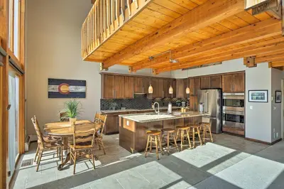 a kitchen with a table and chairs and a refrigerator at Luxurious Grand Lake Vacation Rental with Hot Tub! in Grand Lake