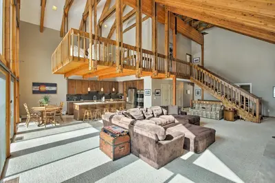 a large living room with couches and a kitchen at Luxurious Grand Lake Vacation Rental with Hot Tub! in Grand Lake