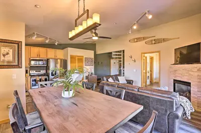 a dining room and living room with a wooden table and chairs at Newly Remodeled Mtn-View Condo in Silverthorne in Silverthorne