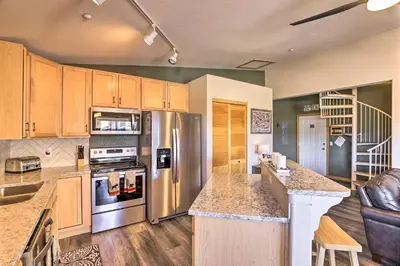 a kitchen with stainless steel appliances and wooden cabinets at Newly Remodeled Mtn-View Condo in Silverthorne in Silverthorne