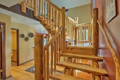 a wooden staircase in a home with wooden floors at Winter Park Cabin - Walk to Main Street and Downtown in Winter Park