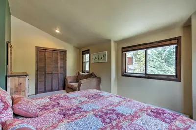 a bedroom with a bed and a chair and a window at Winter Park Cabin - Walk to Main Street and Downtown in Winter Park