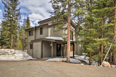 a house with a garage in the woods at Winter Park Cabin - Walk to Main Street and Downtown in Winter Park