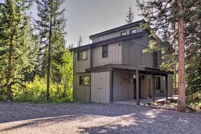 a large house with a garage in the woods at Winter Park Cabin - Walk to Main Street and Downtown in Winter Park