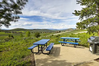 two picnic tables and a grill in a field at Ski, Soak and Explore! Granby Getaway with Mtn Views in Granby