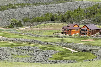 an aerial view of a golf course with a house at Ski, Soak and Explore! Granby Getaway with Mtn Views in Granby
