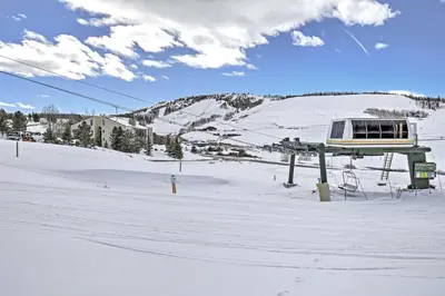 a ski lift with a snow covered mountain in the background at Ski, Soak and Explore! Granby Getaway with Mtn Views in Granby