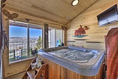 a jacuzzi tub in a wooden room with a tv at Ski, Soak and Explore! Granby Getaway with Mtn Views in Granby
