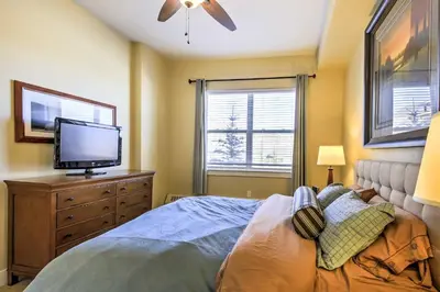 a bedroom with a bed and a flat screen tv at Ski-InandSki-Out Access Mtn-View Granby Condo! in Granby