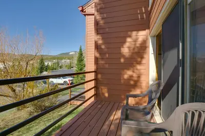 a deck with a chair and a view of the mountains at Silverthorne Condo Patio, Mtn Views, Pool Access! in Silverthorne