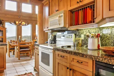 a kitchen with white appliances and a dining room at 7 Mi to Granby Ranch Secluded Cabin with Mtn Views! in Granby