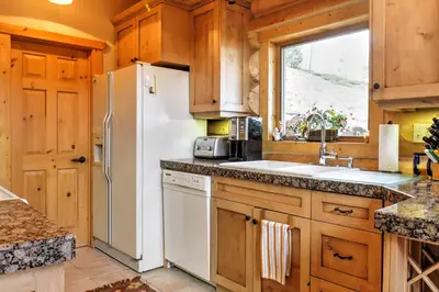 a kitchen with a white refrigerator and a sink at 7 Mi to Granby Ranch Secluded Cabin with Mtn Views! in Granby