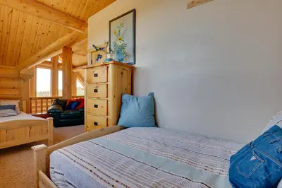 a bedroom with a bed and a dresser in a cabin at 7 Mi to Granby Ranch Secluded Cabin with Mtn Views! in Granby