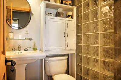 a bathroom with a toilet and a sink and a mirror at 7 Mi to Granby Ranch Secluded Cabin with Mtn Views! in Granby