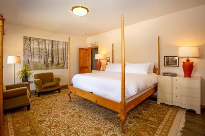 a bedroom with a four poster bed and a chair at Mtn-View Retreat with Hot Tub in Granby! in Granby