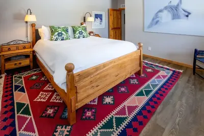 a bedroom with a bed and a red rug at Mtn-View Retreat with Hot Tub in Granby! in Granby
