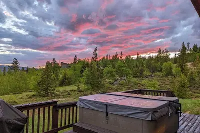 a hot tub sitting on a deck with a sunset at Mtn-View Retreat with Hot Tub in Granby! in Granby