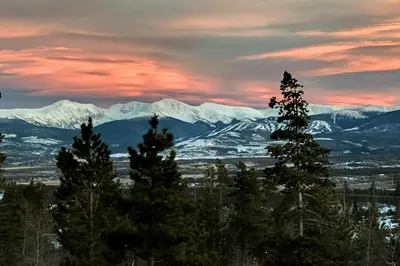 a view of snow covered mountains with trees in the foreground at Mtn-View Retreat with Hot Tub in Granby! in Granby