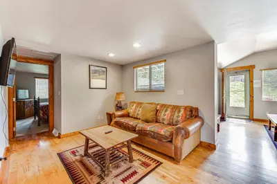 a living room with a leather couch and a table at 2 Mi to Downtown Home with Hot Tub in Estes Park! in Estes Park