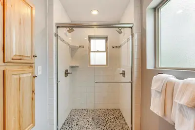 a bathroom with a shower with a glass door at 2 Mi to Downtown Home with Hot Tub in Estes Park! in Estes Park