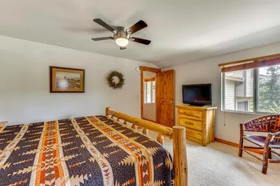 a bedroom with a bed and a ceiling fan at 2 Mi to Downtown Home with Hot Tub in Estes Park! in Estes Park