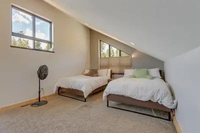a attic bedroom with two beds and a fan at Fraser House with Mtn Views Near Winter Park! in Fraser