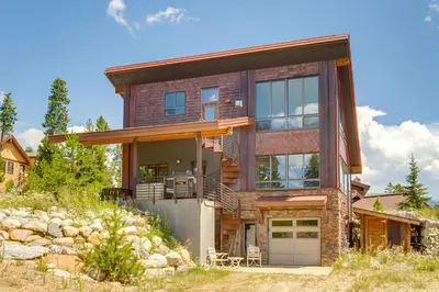 a large house with glass doors on a hill at Fraser House with Mtn Views Near Winter Park! in Fraser