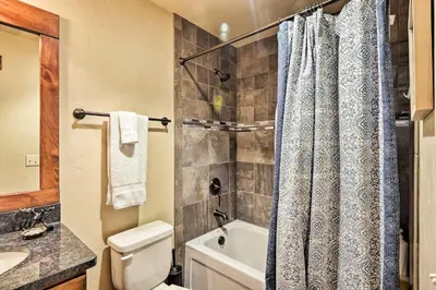 a bathroom with a toilet and a shower curtain at Winter Park Condo with Hot Tub and Mountain Views! in Winter Park