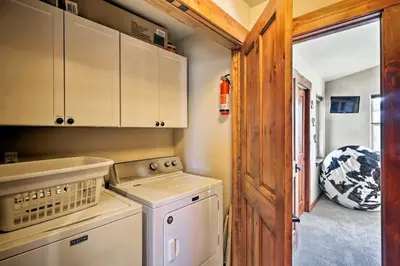 a small kitchen with a washer and dryer at Winter Park Condo with Hot Tub and Mountain Views! in Winter Park