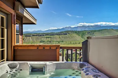 a hot tub on a balcony with a mountain view at Winter Park Condo with Hot Tub and Mountain Views! in Winter Park
