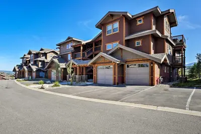 a large house with two garages on a street at Winter Park Condo with Hot Tub and Mountain Views! in Winter Park
