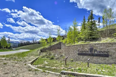 a sign on a brick wall next to a road at Winter Park Condo with Hot Tub and Mountain Views! in Winter Park
