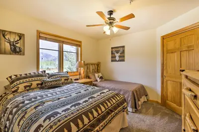 a bedroom with a bed and a ceiling fan at Steps to Grand Lake Condo with Deck and Mtn Views in Grand Lake