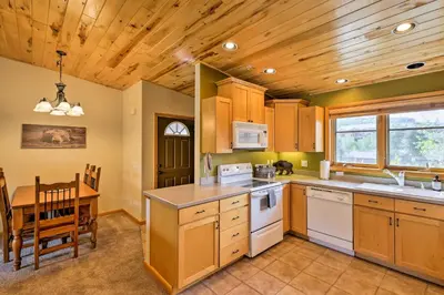 a kitchen with a wooden ceiling and a table and chairs at Steps to Grand Lake Condo with Deck and Mtn Views in Grand Lake