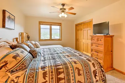 a bedroom with a bed and a ceiling fan at Steps to Grand Lake Condo with Deck and Mtn Views in Grand Lake