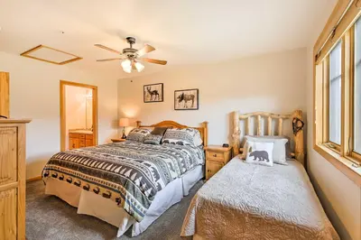 a bedroom with a bed and a window at Steps to Grand Lake Condo with Deck and Mtn Views in Grand Lake