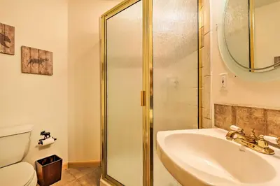 a bathroom with a shower and a sink and a toilet at Steps to Grand Lake Condo with Deck and Mtn Views in Grand Lake