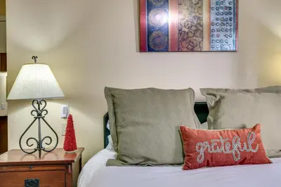 a bedroom with a bed with a red pillow and a lamp at Half-Mi to Light Rail Greenwood Village Studio in Englewood