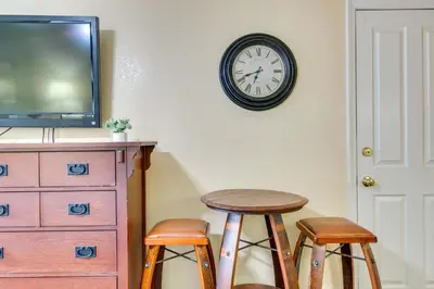 a clock on the wall above a dresser and two stools at Half-Mi to Light Rail Greenwood Village Studio in Englewood