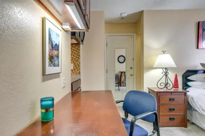 a bedroom with a desk and a bed and a blue chair at Half-Mi to Light Rail Greenwood Village Studio in Englewood